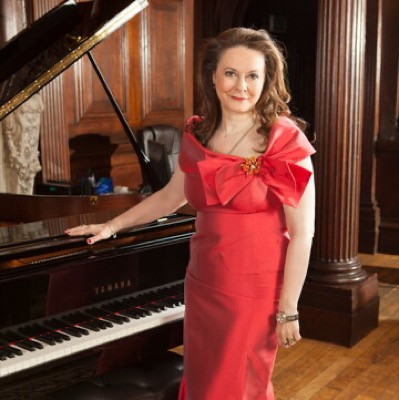 Olga Thomas — Executive Producer of Virtuoso TV, by a grand piano